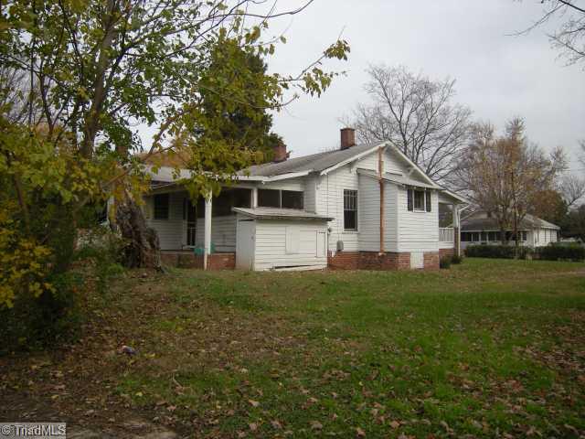 Exterior Back. Level lot, has older sheds on back of property.