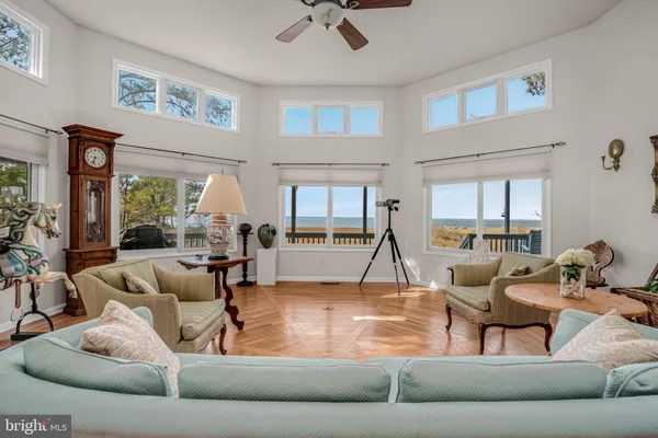 a living room with a couch and a dining table with wooden floor
