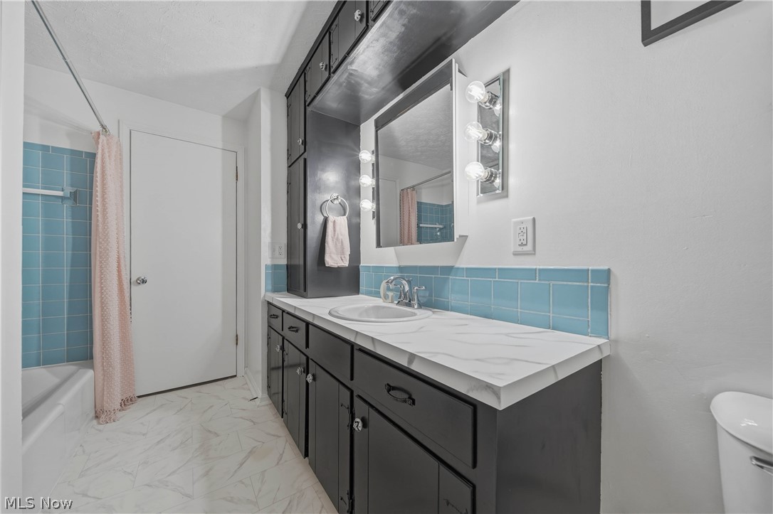 702 Perry Drive Northwest Canton, OH 44708 - Photo 19 of 46 Full bath featuring vanity, shower / bath combination with curtain, and light marble finish floors