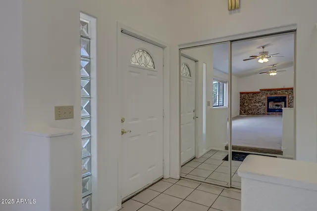 an empty room with windows and fan