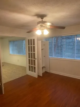 an empty room with wooden floor and windows