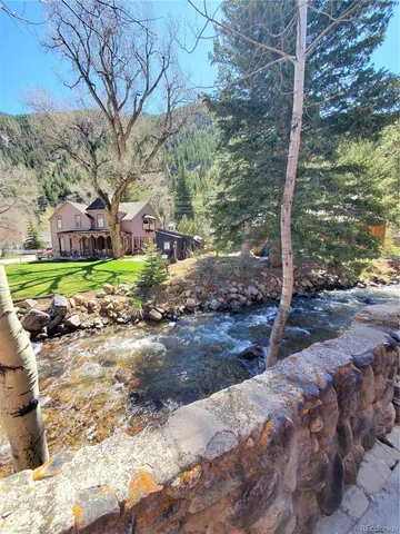 a backyard of a house with trees and wooden fence