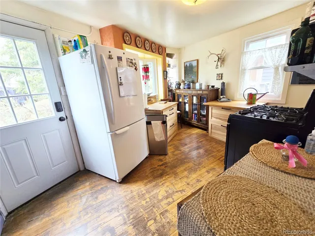 a living room with furniture and a refrigerator