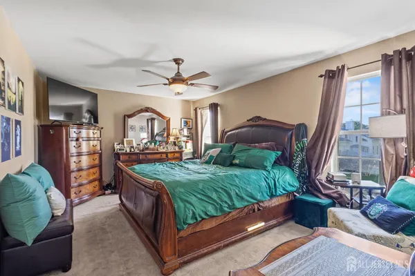 a bed sitting in a bedroom next to a larger window