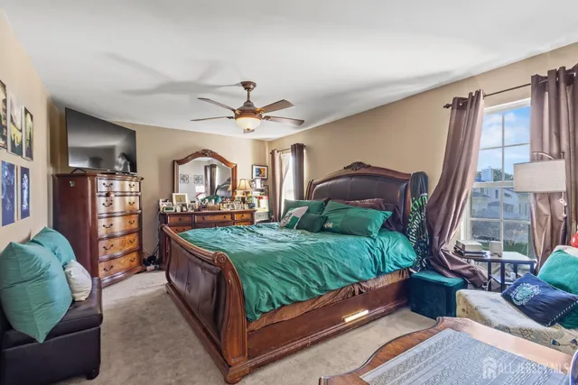 a bed sitting in a bedroom next to a larger window