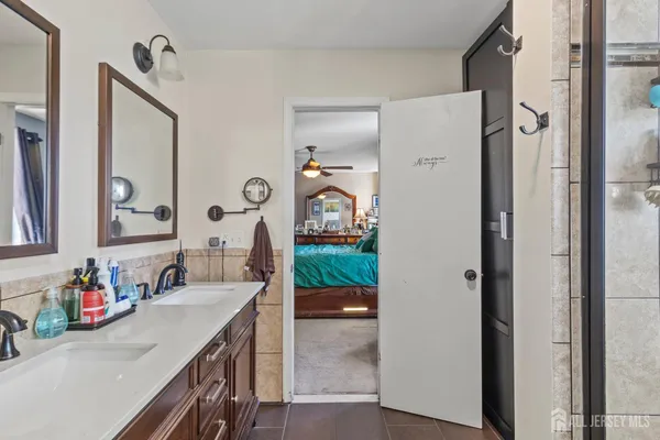 a en suite bathroom with a granite countertop sink and a mirror