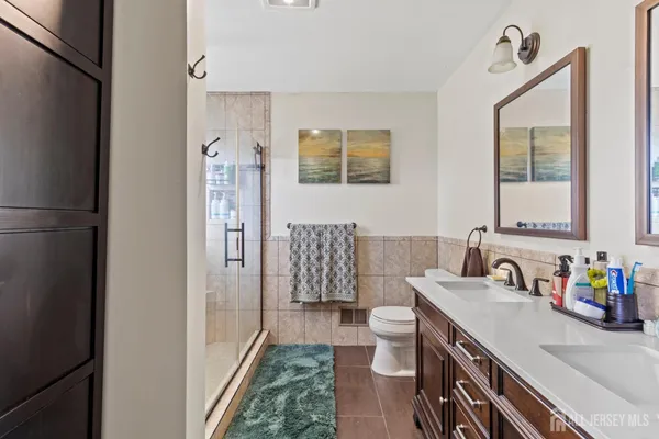 a bathroom with a sink a toilet a mirror and shower