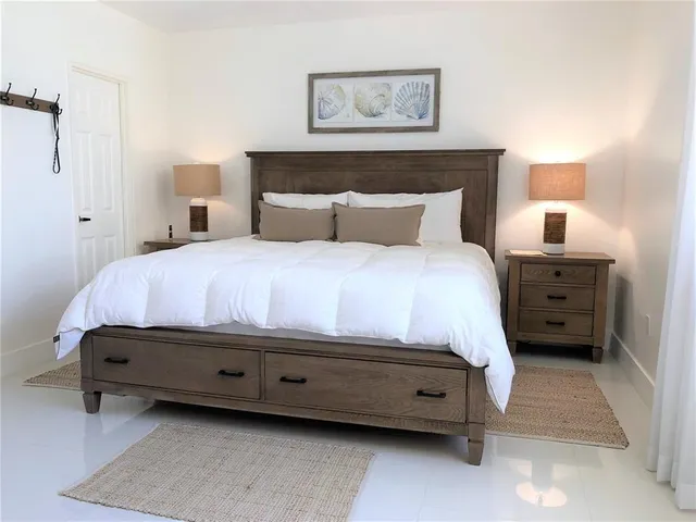 a bedroom with a bed and a lamp on dresser
