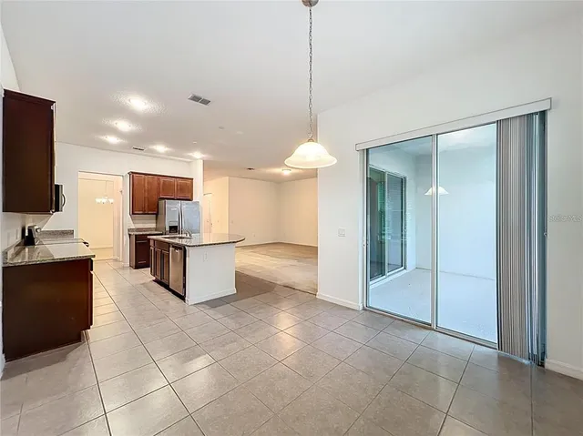 a large kitchen with granite countertop a large counter top and appliances