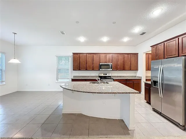 a kitchen with kitchen island a sink stainless steel appliances and cabinets
