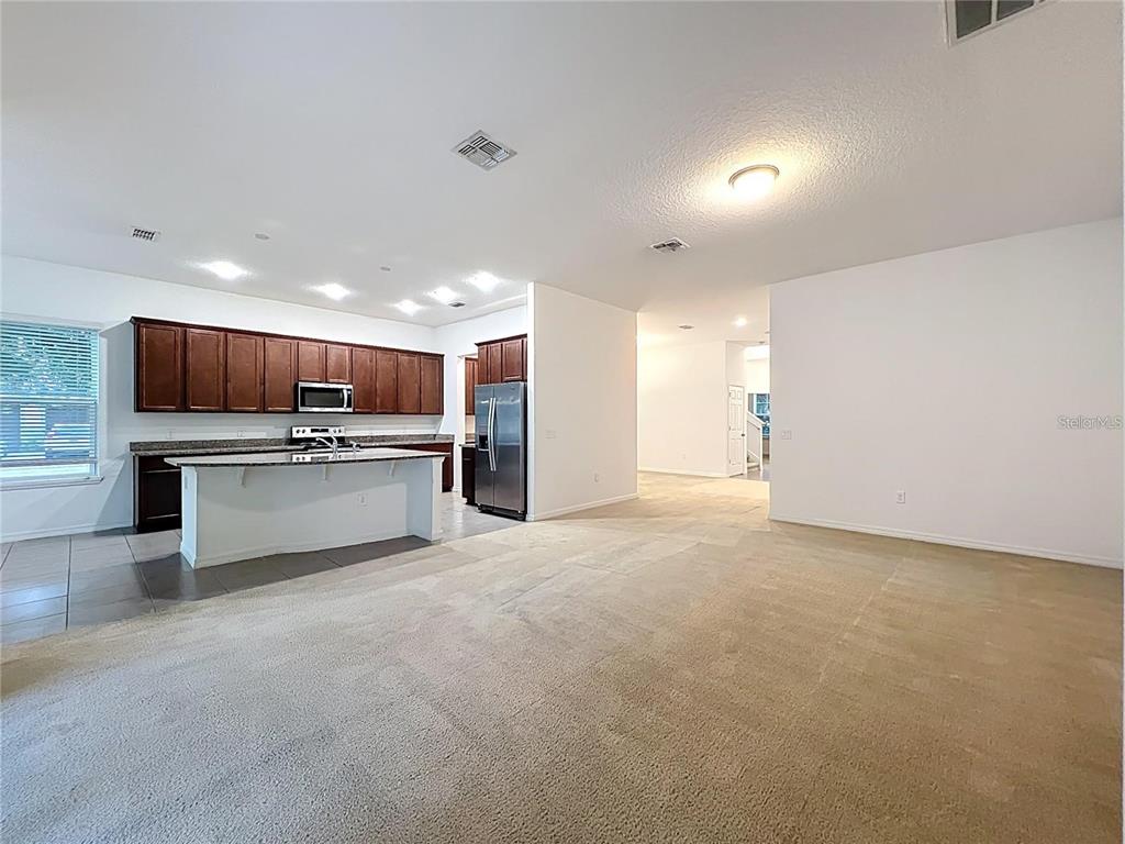 12821 Westside Vlg Loop Windermere, FL 34786 - Photo 15 of 42 a large kitchen with stainless steel appliances kitchen island a large counter top and a view of kitchen