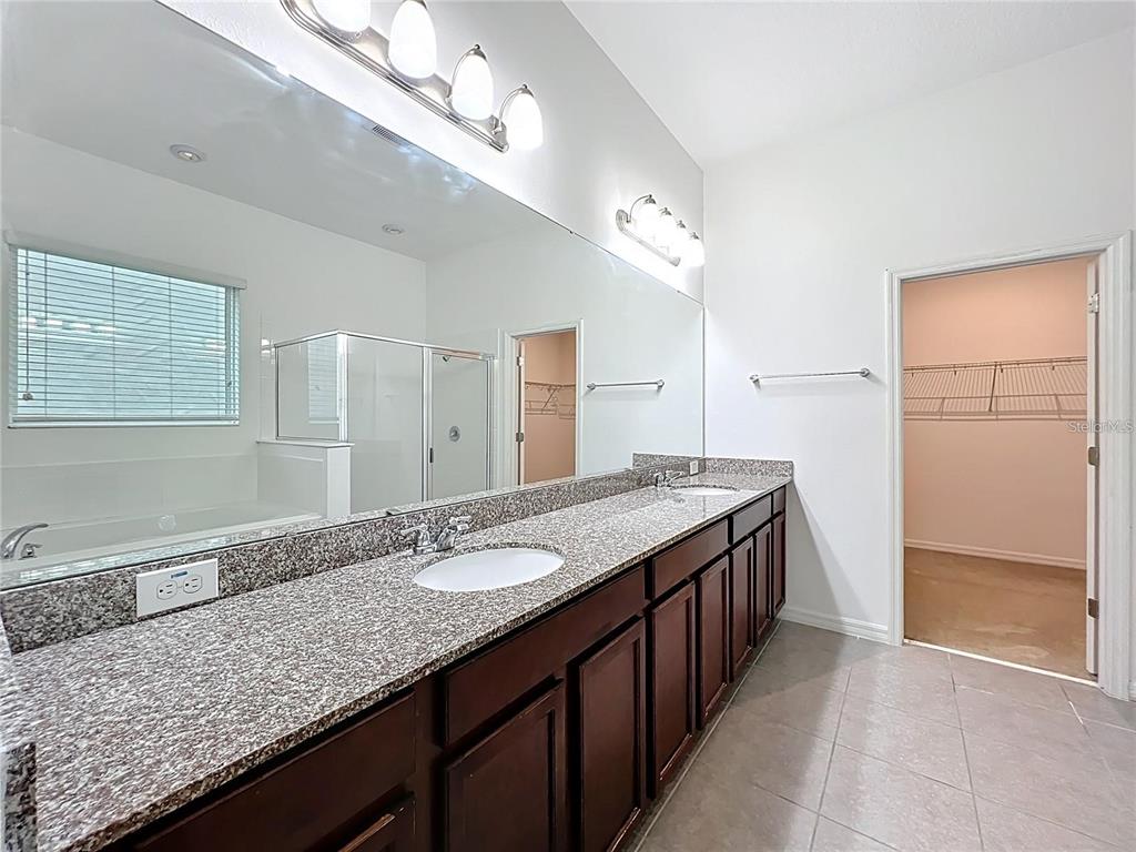12821 Westside Vlg Loop Windermere, FL 34786 - Photo 20 of 42 a bathroom with a granite countertop double vanity sink and mirror