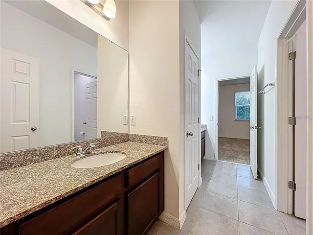 a bathroom with a granite countertop sink and a mirror