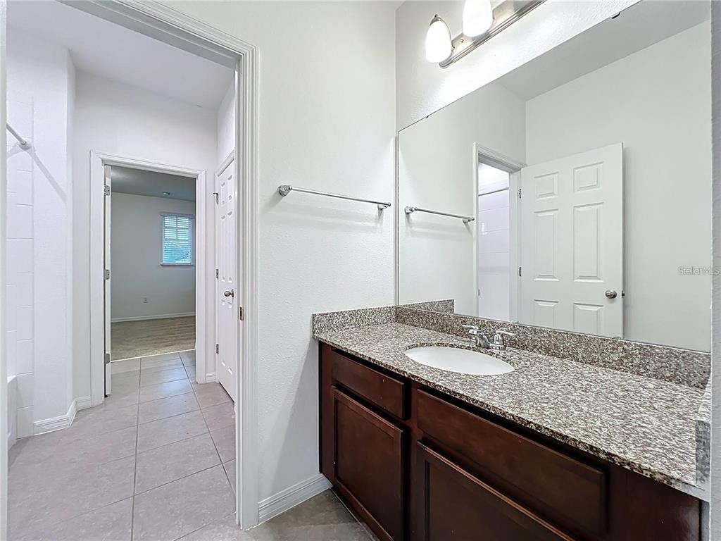 12821 Westside Vlg Loop Windermere, FL 34786 - Photo 34 of 42 a bathroom with a granite countertop sink and a mirror