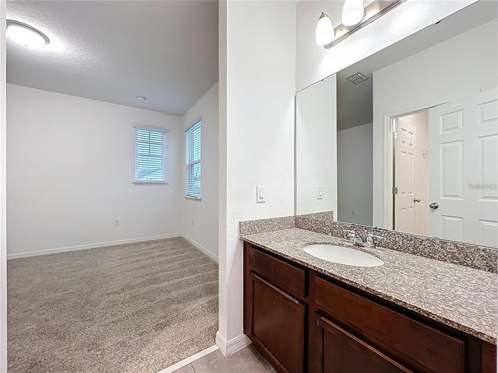 12821 Westside Vlg Loop Windermere, FL 34786 - Photo 36 of 42 a bathroom with a granite countertop sink and a mirror
