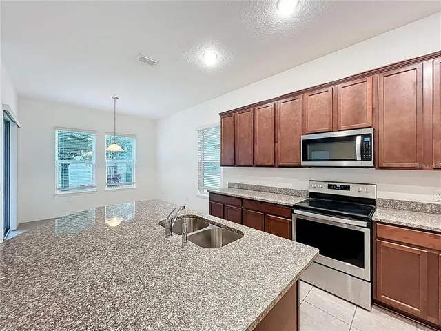 a kitchen with stainless steel appliances granite countertop a sink stove and microwave