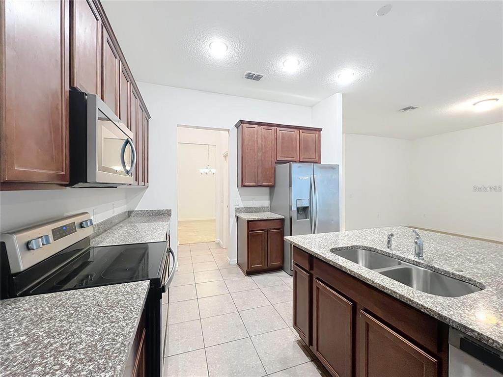 12821 Westside Vlg Loop Windermere, FL 34786 - Photo 9 of 42 a kitchen with a sink stove and refrigerator