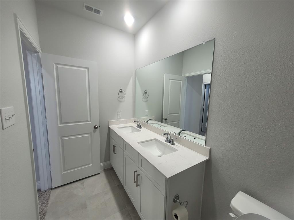 2702 Island Palm Court Forney, TX 75126 - Photo 14 of 15 a bathroom with a sink mirror and toilet