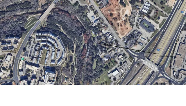 a backyard of a house with large trees and plants