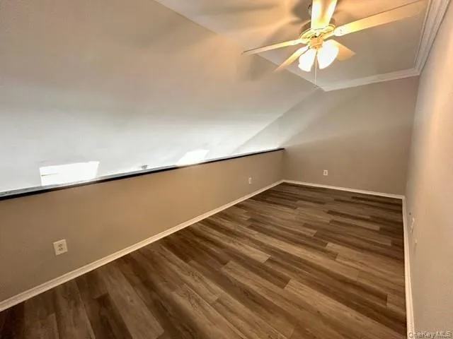 en empty room with wooden floor and fan