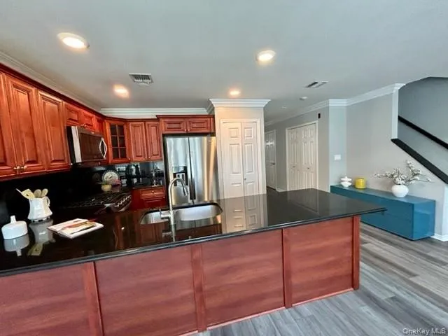 a kitchen with granite countertop stainless steel appliances sink stove microwave and cabinets