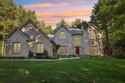 a front view of a house with a garden and plants
