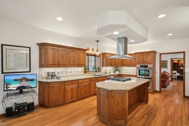 a dining room with furniture a chandelier and wooden floor