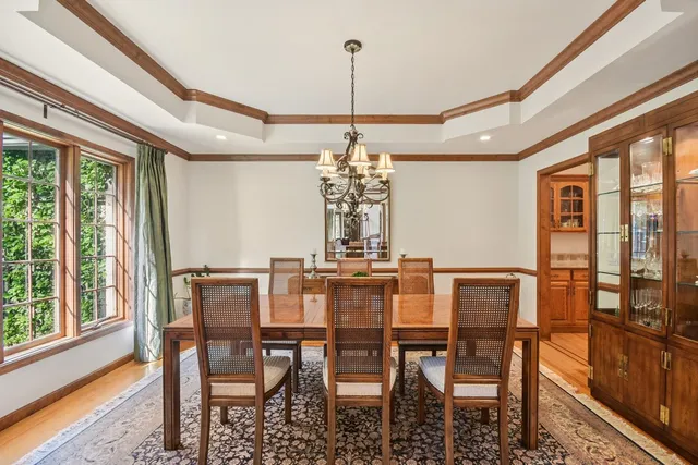 a dining room with furniture a chandelier and wooden floor