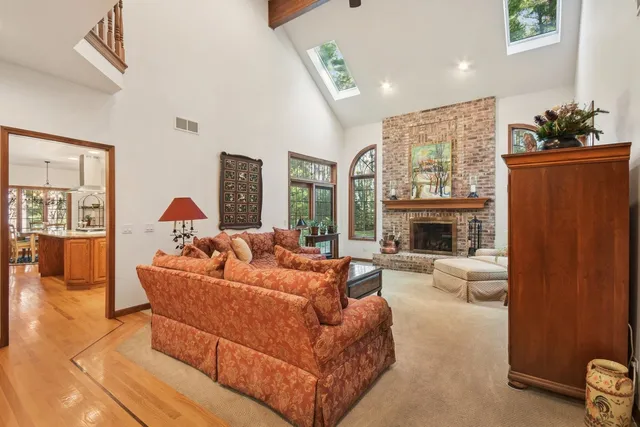 a living room with furniture a fireplace and a large window