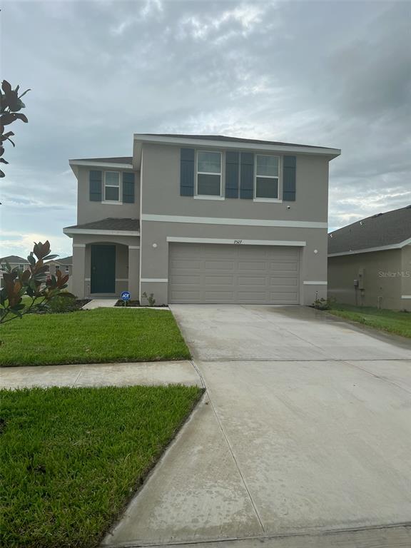 a front view of a house with a yard and garage