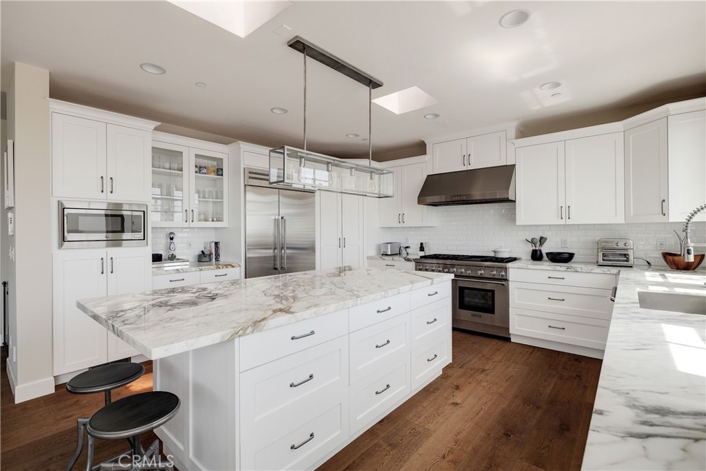 124 23rd Street Manhattan Beach, CA 90266 - Photo 18 of 50 a kitchen with stainless steel appliances kitchen island granite countertop a sink stove and refrigerator