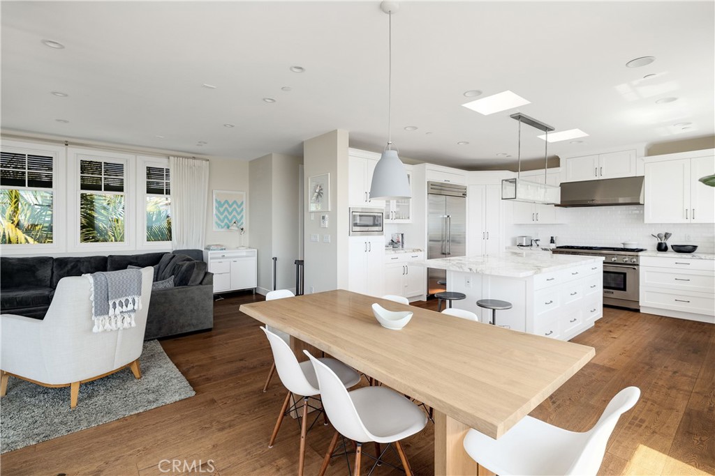124 23rd Street Manhattan Beach, CA 90266 - Photo 30 of 50 a kitchen with stainless steel appliances kitchen island granite countertop a dining table chairs and a refrigerator