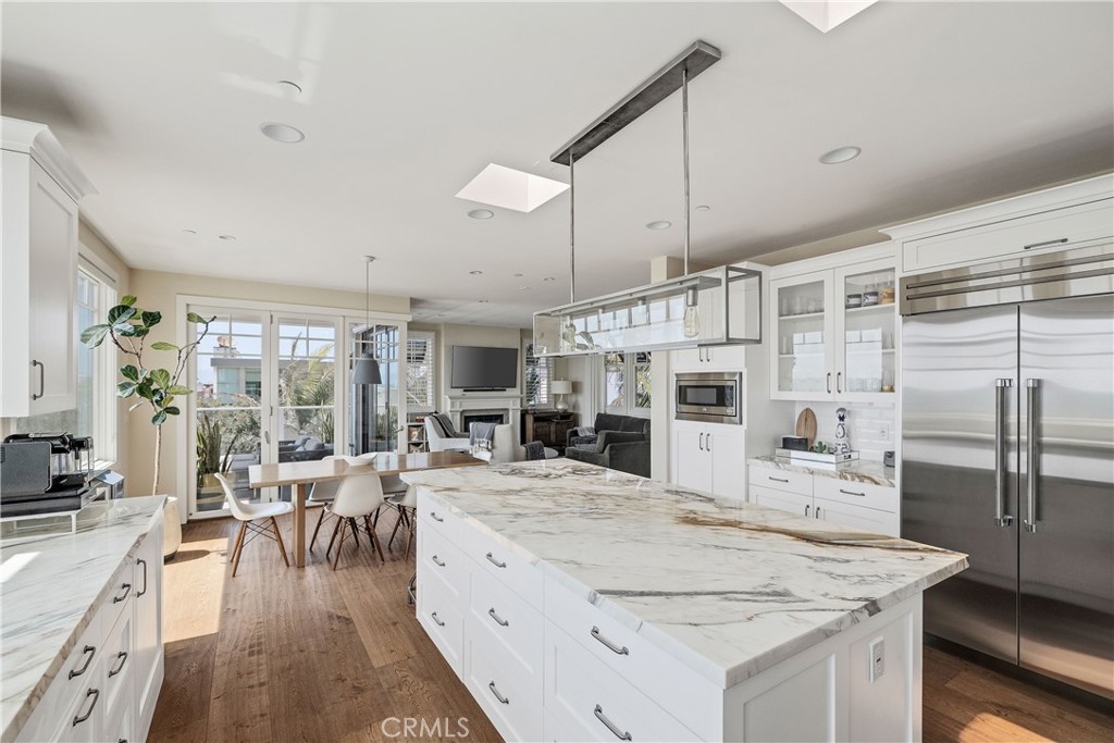 124 23rd Street Manhattan Beach, CA 90266 - Photo 9 of 50 a large kitchen with kitchen island a large counter space a sink appliances and living room view