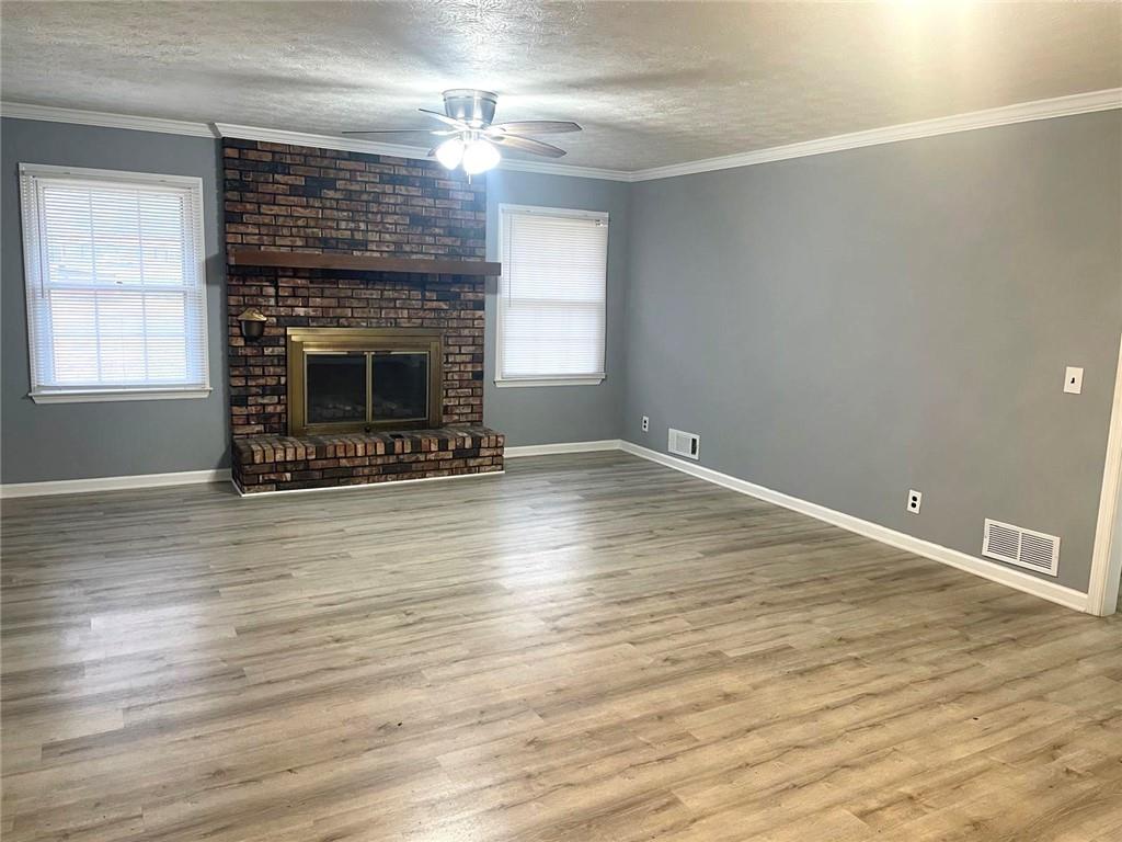 12266 Brown Bridge Road Covington, GA 30016 - Photo 3 of 12 a view of an empty room with wooden floor fireplace and a window
