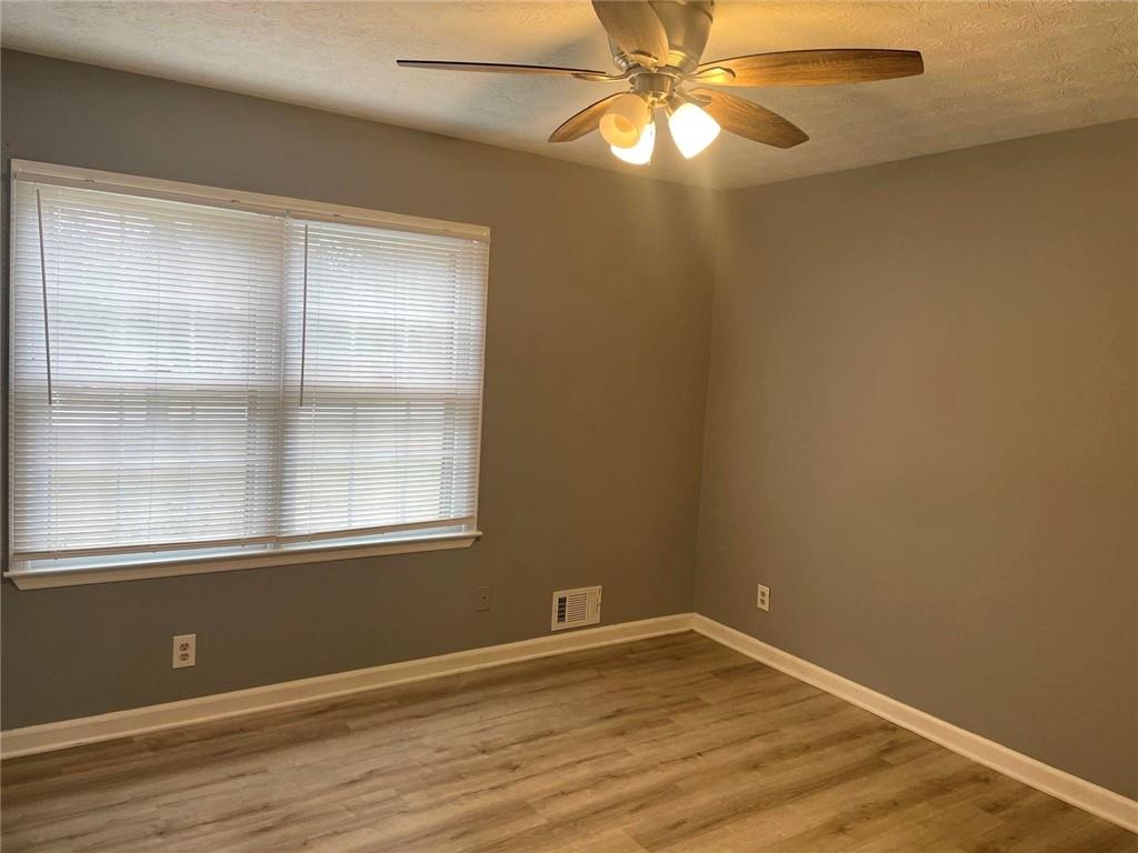 12266 Brown Bridge Road Covington, GA 30016 - Photo 7 of 12 an empty room with wooden floor and windows