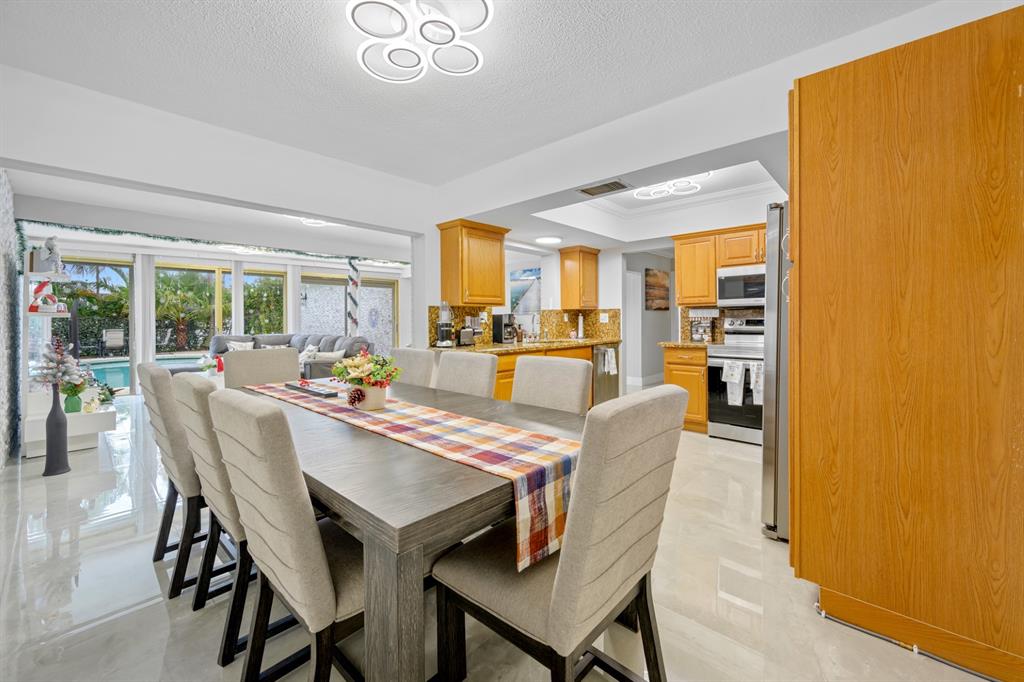 1336 Funston Street Hollywood, FL 33019 - Photo 23 of 51 a dining room with furniture a chandelier and wooden floor