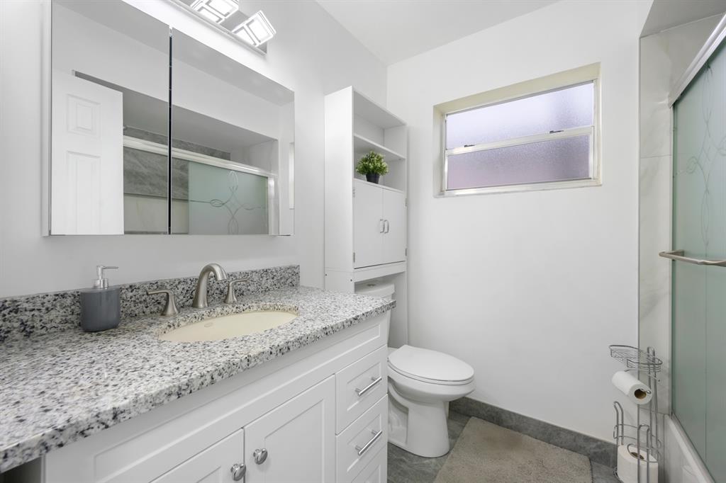 1336 Funston Street Hollywood, FL 33019 - Photo 26 of 51 a bathroom with a granite countertop sink a toilet and a mirror