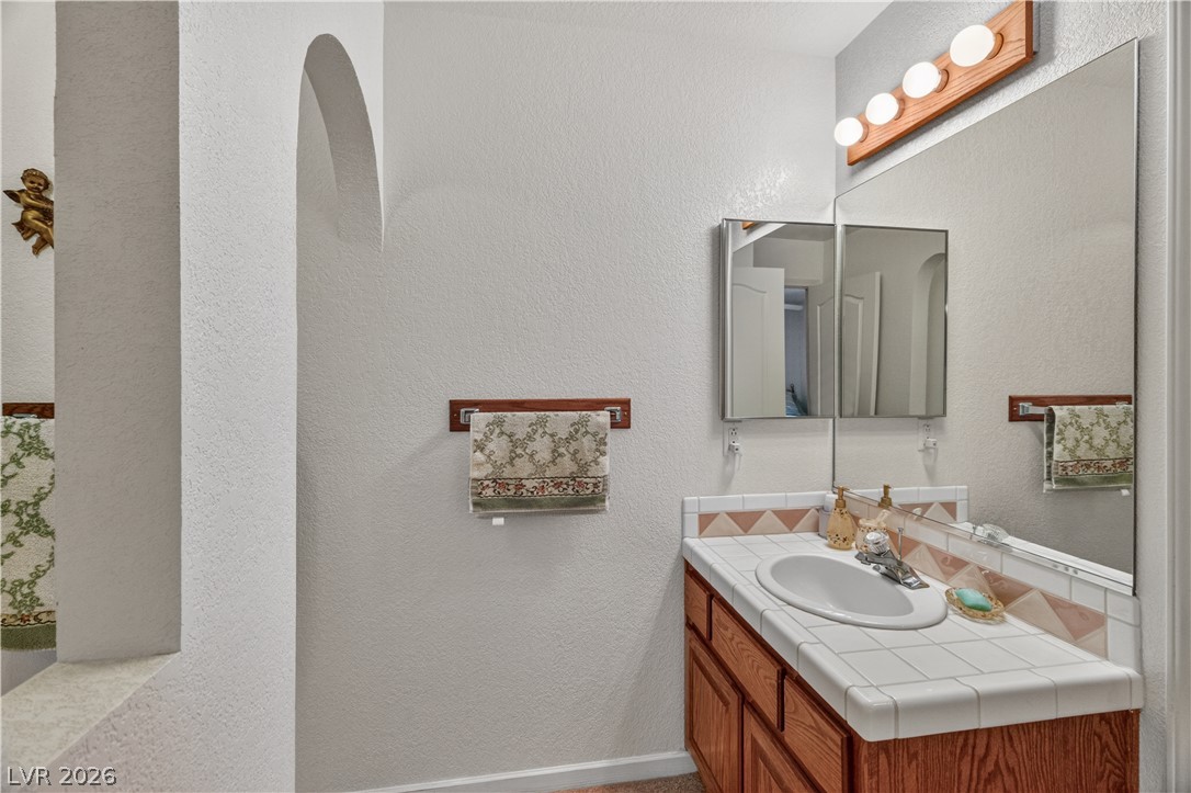 2055 Cholla Way Laughlin, NV 89029 - Photo 24 of 87 A classic tiled vanity with a large mirror defines this functional bathroom space.
