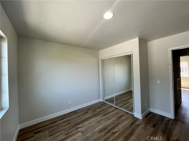 an empty room with wooden floor and closet