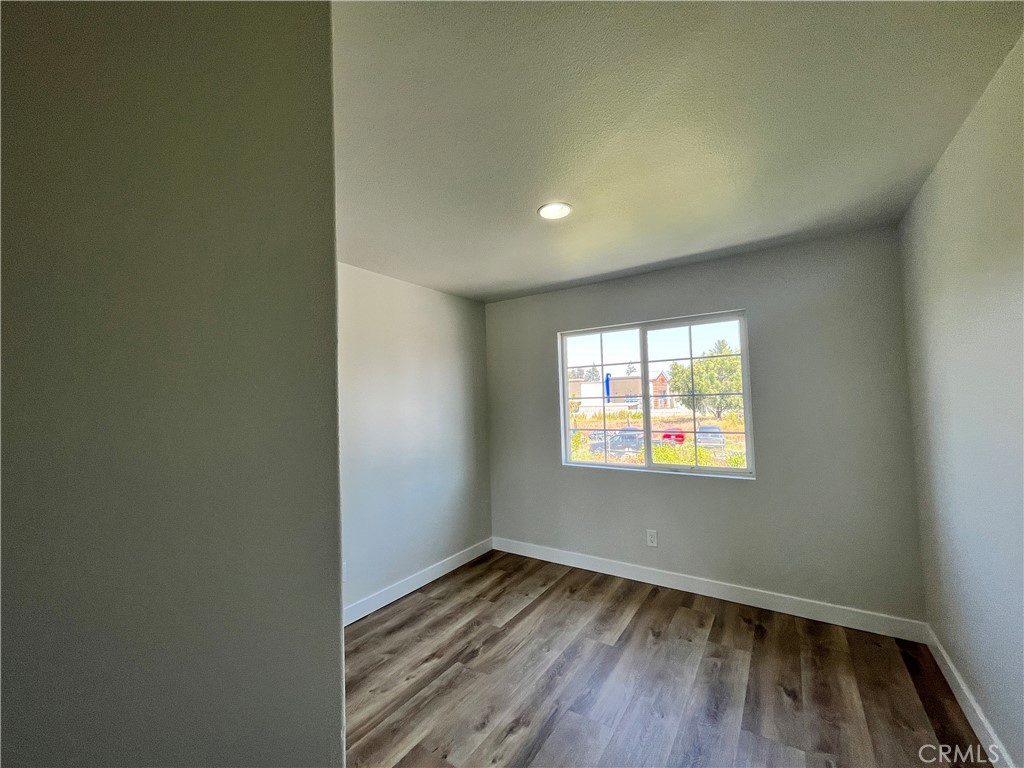 1004 South Riverside Avenue, Unit A3 Rialto, CA 92376 - Photo 5 of 10 an empty room with wooden floor and windows