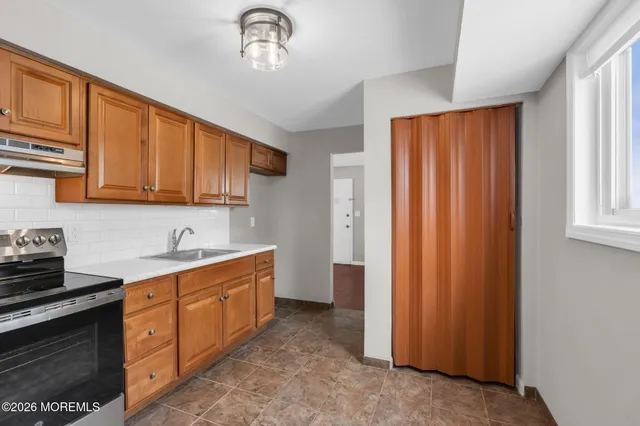 a kitchen with stainless steel appliances granite countertop a refrigerator a sink dishwasher and wooden cabinets