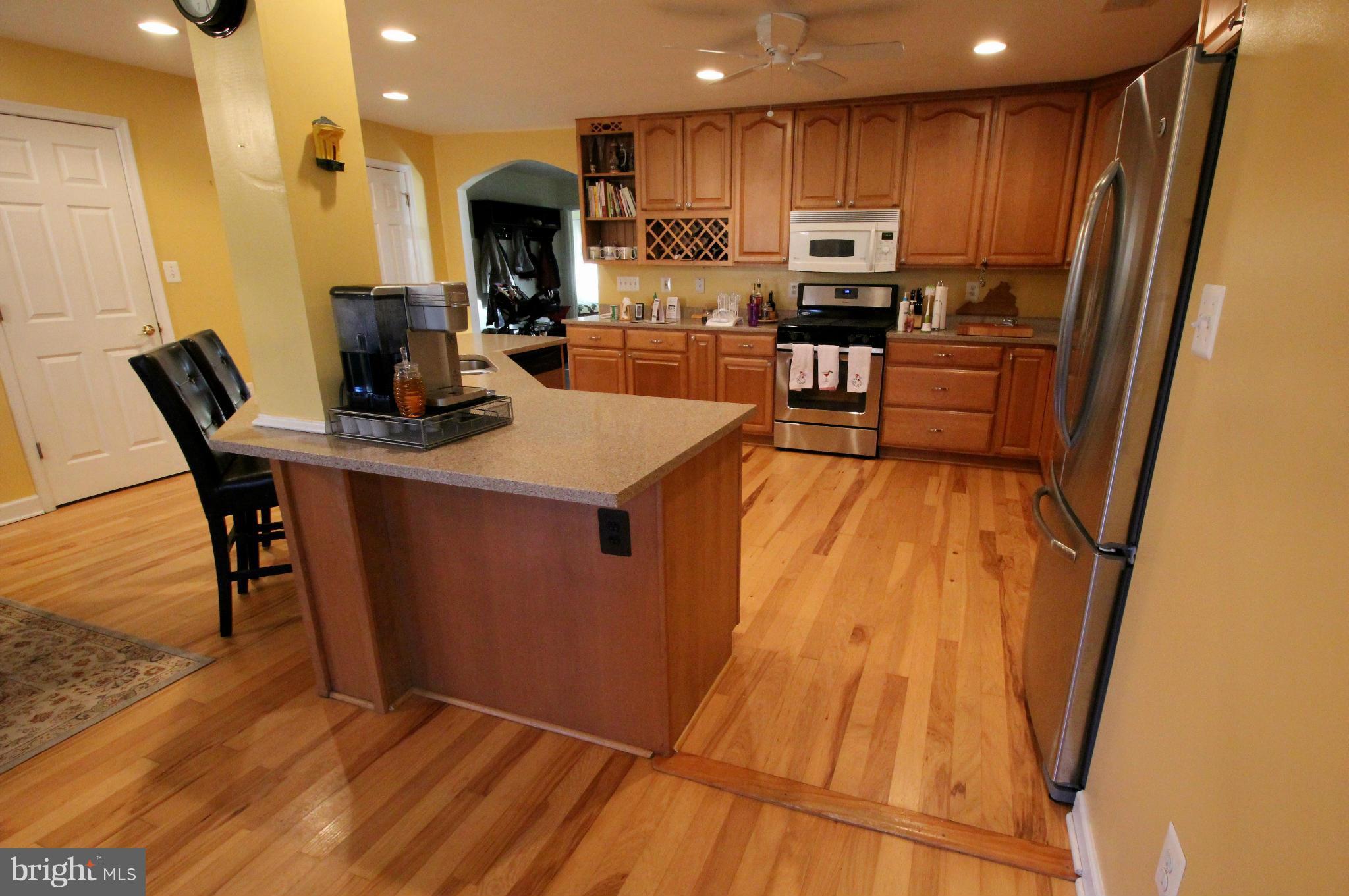 7308 Inzer Street Springfield, VA 22151 - Photo 7 of 30 a kitchen with stainless steel appliances wooden floors and wooden cabinets