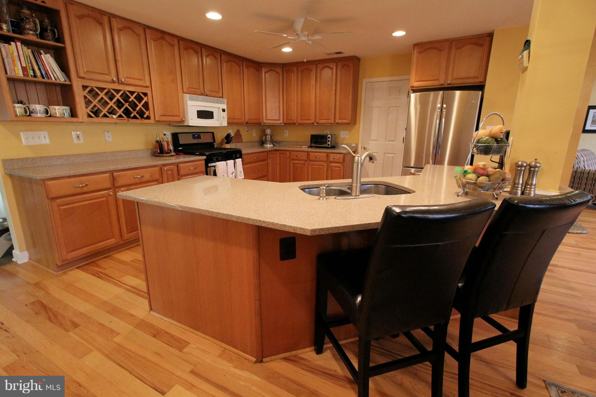 7308 Inzer Street Springfield, VA 22151 - Photo 8 of 30 a kitchen with stainless steel appliances kitchen island granite countertop a table chairs sink and cabinets