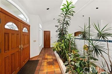 3786 Foxglove Lane Fallbrook, CA 92028 - Photo 9 of 34 a hallway with potted plants and a palm tree