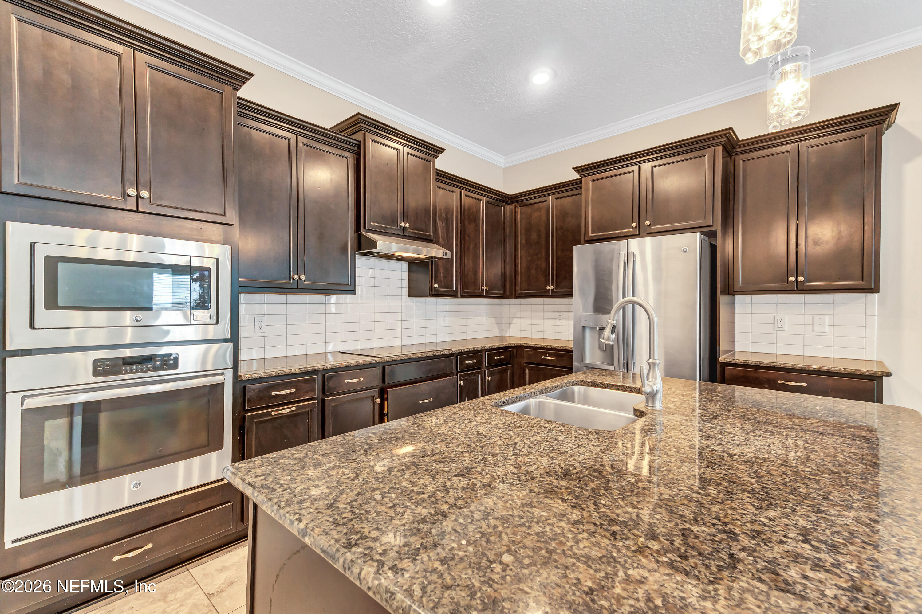15715 Tisons Bluff Road Jacksonville, FL 32218 - Photo 14 of 48 a kitchen with granite countertop a refrigerator and a sink