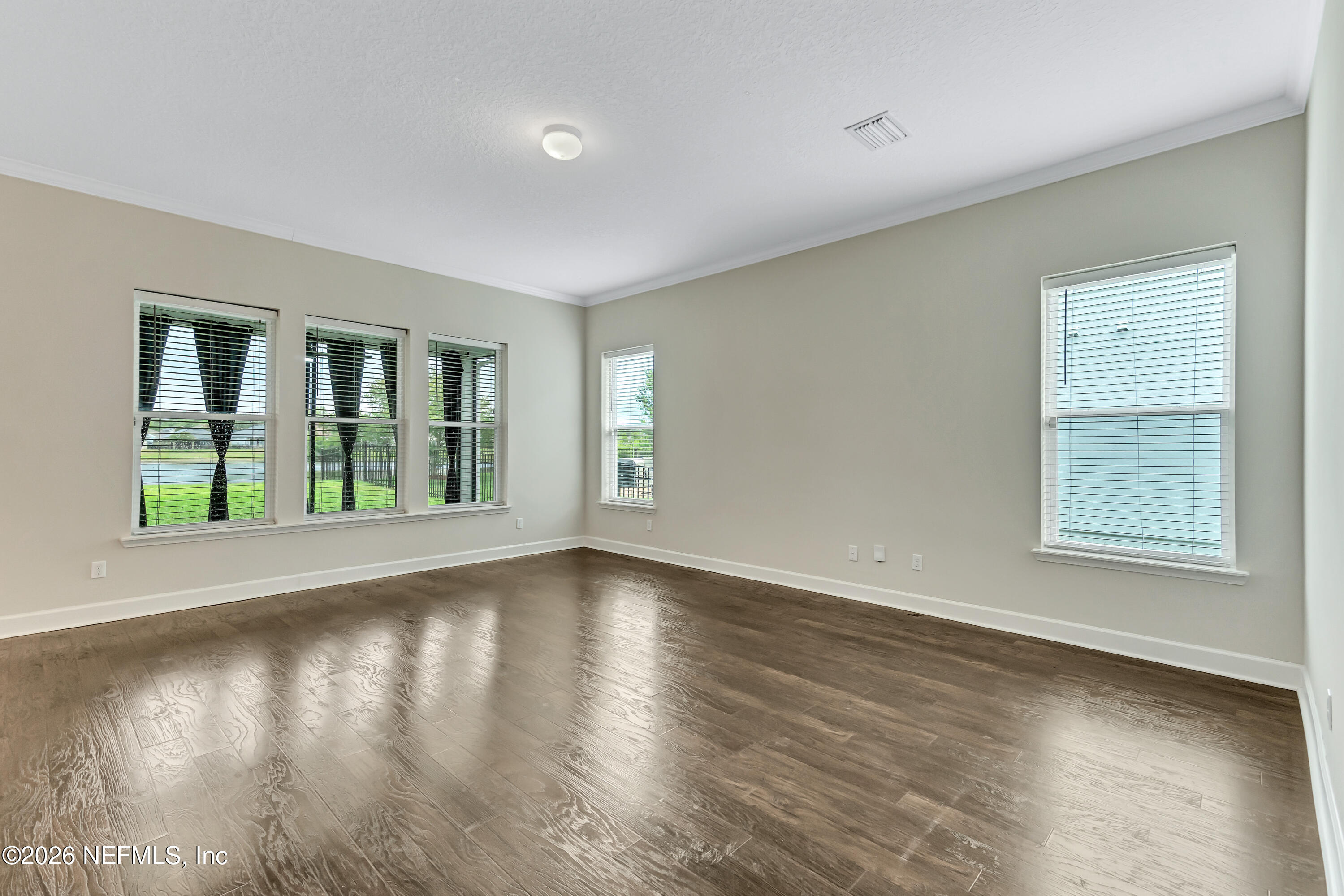 15715 Tisons Bluff Road Jacksonville, FL 32218 - Photo 17 of 48 a view of an empty room with wooden floor and a window