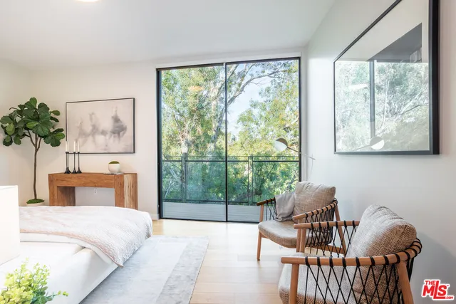 a bedroom with a bed and a large window