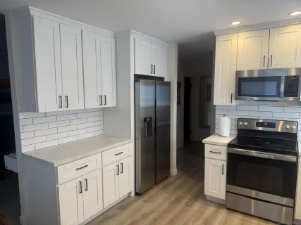 a kitchen with white cabinets and stainless steel appliances