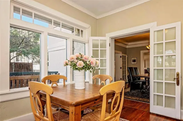 a dining room with furniture potted plants and wooden floor
