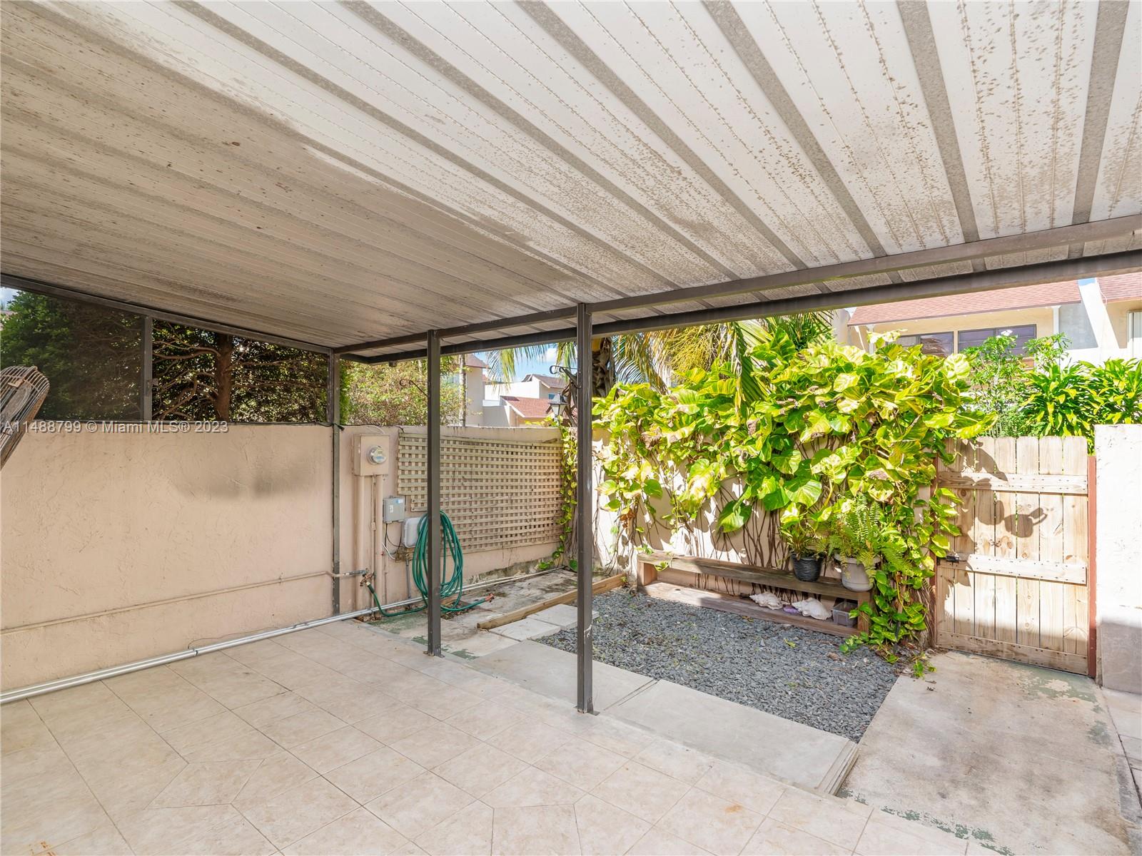 8236 Southwest 103rd Avenue Miami, FL 33173 - Photo 22 of 24 a porch with a table and chairs and potted plants